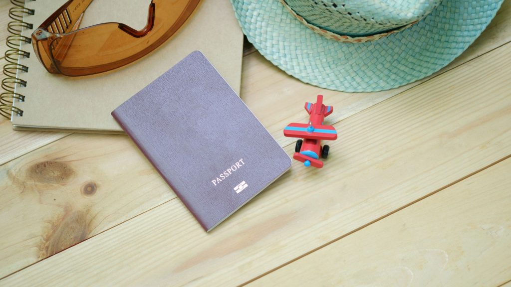 Un chapeau, des lunettes de soleil et un passeport sur une table
